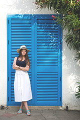 A girl is posing by the blue door