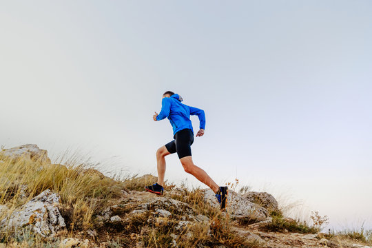 Running Uphill On Stones Male Athlete Runner Side View