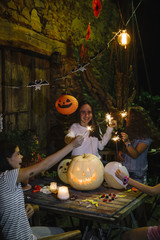 Group of friends in the party with pumpkin, candies and soft drinks