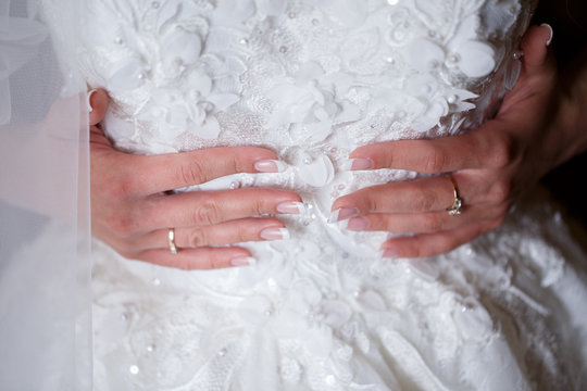 beautiful French manicure for the bride on a background of a wedding dress