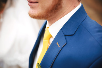 wedding stylish blue suit with a yellow tie and yellow flower