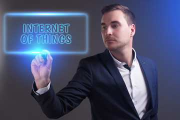 The concept of business, technology, the Internet and the network. Young businessman showing inscription: Internet of things