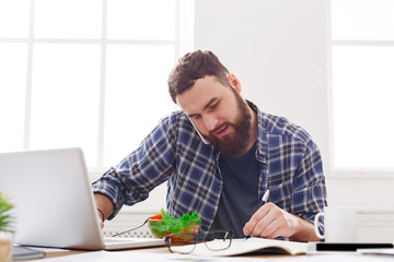 Busy man has business lunch in modern office interior