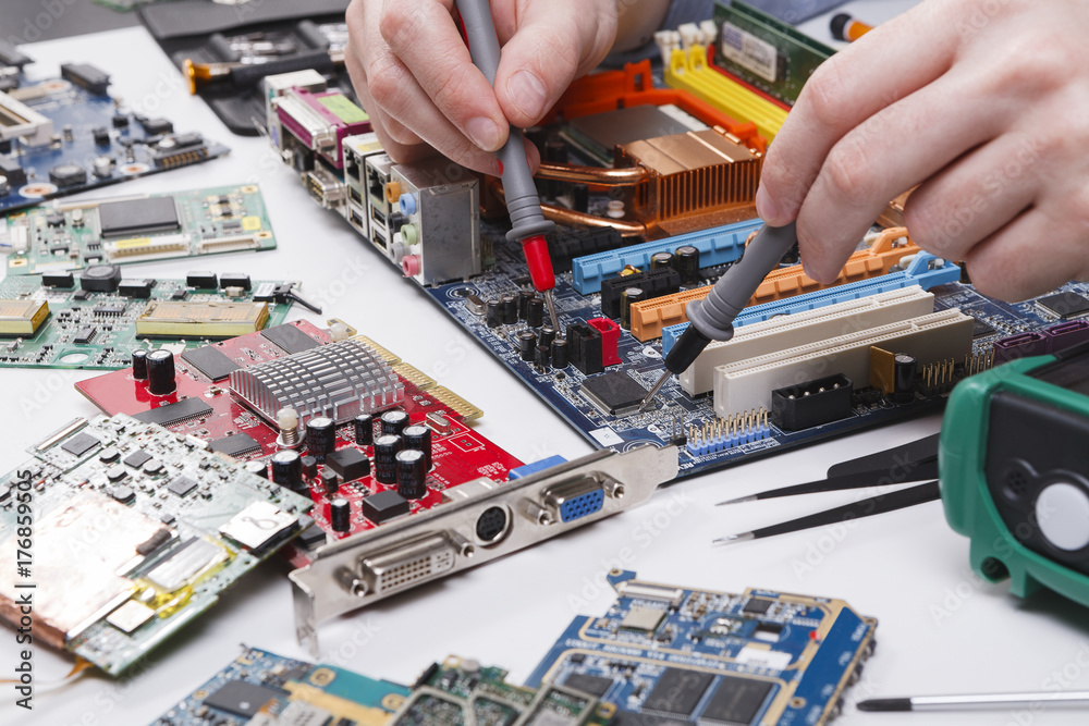 Poster Engineer checking motherboard with multimeter