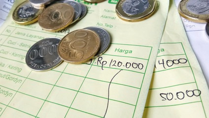 Illustration for payment receipt calculation article with Indonesia rupiah and singapore dollar coins and invoices