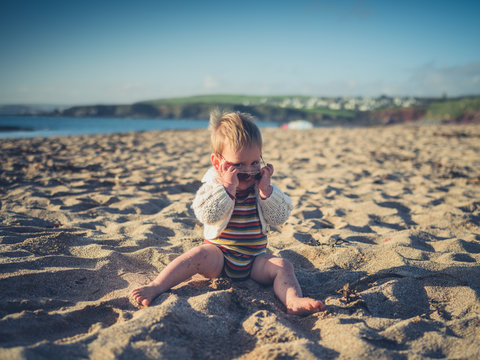 Baby with sunglasses on the beach