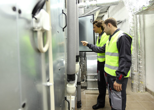 Workers In Electrical Switchgear Room