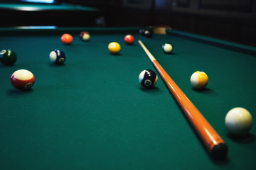 Playing billiard. Billiards balls and cue on green billiards table. Billiard sport concept.