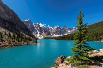 Fototapeta na wymiar Beautiful turquoise waters of the Moraine Lake with snow-covered peaks above it in Rocky Mountains, Banff National Park, Canada.
