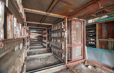 Fototapeta na wymiar Old broken and rusted equipment of an abandoned textile factory