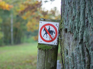 Horse riding prohibited or forbidden sign in black, white, red in forest near Berlin, Germany