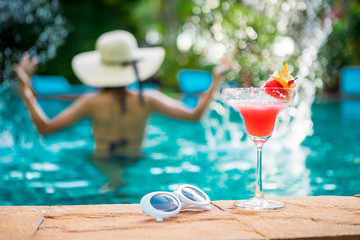 Women wearing bigini or swimware suits, swimming pool, Drinking water melon smoothie at the resort town of Pattaya in Thailand.