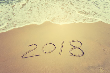 2018 written in sand write on tropical beach