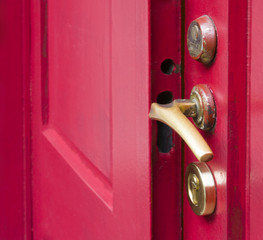 Close up to ajar old red door.