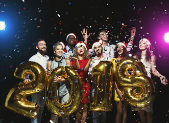 Group of young happy friends with number balloons at new year party