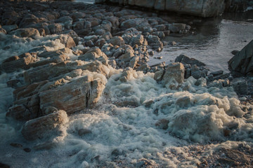 Fototapeta na wymiar Rocks with Foam over it from rough sea
