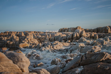 Fototapeta na wymiar Rough sea with foam over rocks
