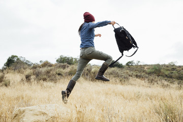 Girl jumping off rock on nature walk