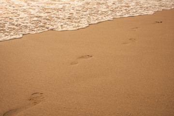 Footprints on sand of sunset beach