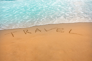 Drawing of word travel on sand