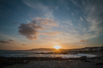 Colorful Sunset with Dramatic Clouds Over Ocean & Mountain