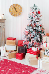 Christmas and New Year details of home interior - wooden deer, mantelpiece with candles, Eve tree and presents.