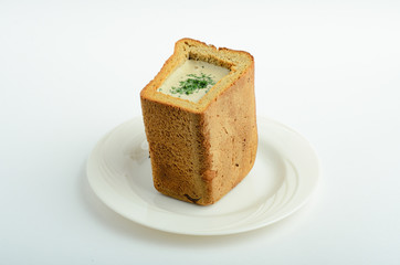 Mashroom crean soup in bread decorated greens isolated on white background