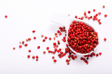 Organic Pink Peppercorn in ceramic white cup on white background