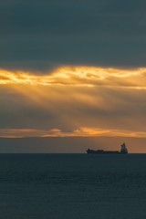 Container Cargo ship in the ocean at sunset sky, silhouette
