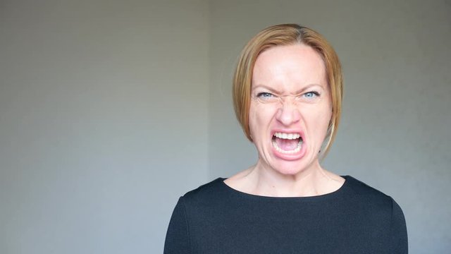 4k. Close-up of a beautiful blonde with bright blue eyes. Portrait of a young woman. sign language and gestures. she gets angry and yells at the camera