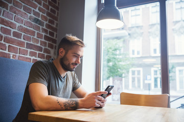 Man in the cafe using his mobile phone