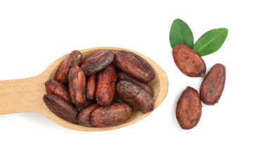 unpeeled cocoa beans in a wooden spoon with leaf isolated on white background close-up top view