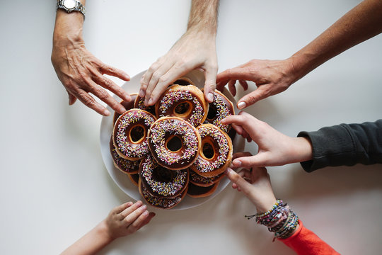 Overhead image of a group of friends sharing a pile of donuts.
