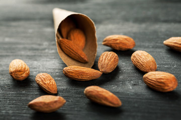 Paper cone bag with almond on a black wooden board