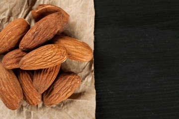Almond on a piece of wrinkled craft paper on a wooden table, copy space