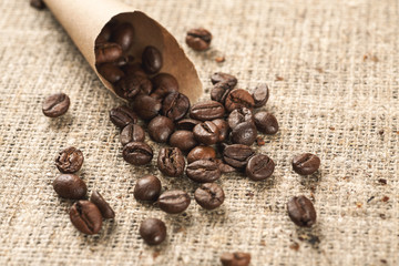 Paper cone bag with roasted coffee beans on a burlap