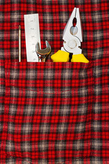 Hand tools in checkered shirt pocket
