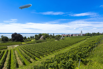 The village Hagnau at Lake Constance with vineyards in the foreground and zeppelin - Hagnau, Lake Constance, Baden-Wuerttemberg, Germany, Europe © karlo54