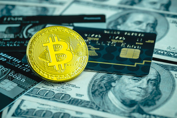Golden bitcoin with credit card on top of dollar banknote background, new currency, accepting bitcoin for payment, finance concept