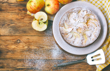 homemade apple pie on a plate sprinkled with sugar powder
