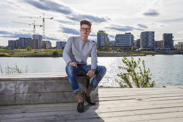 Fototapeta na wymiar Handsome young man wearing jeans, sweater and sunglasses