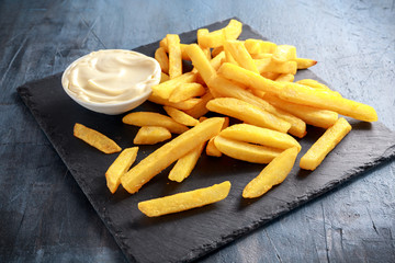 Homemade Baked Potato Fries with Mayonnaise on black stone board