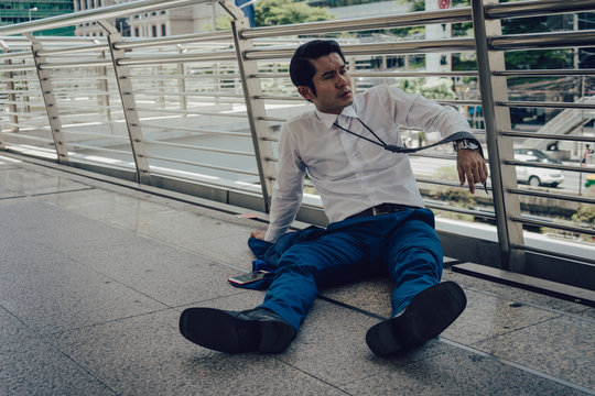businessman unemployed from company sitting on the street, A man desperate want to commit suicide. concept of business failure and unemployment problem