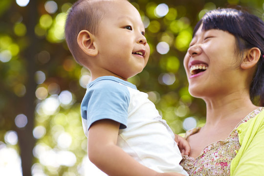 happy young asian woman with her son outdoor
