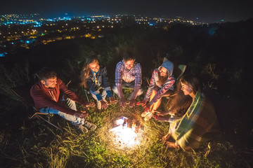 Naklejka premium The five friends warming near the bonfire. evening night time