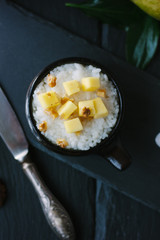 Top view of mango and rice dessert over black background.