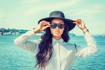 Young American Woman with long hair traveling in New York in summer, wearing white striped shirt,...