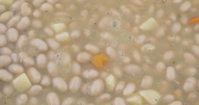 Close video of hot bean soup bubbling and steaming as it heats up.