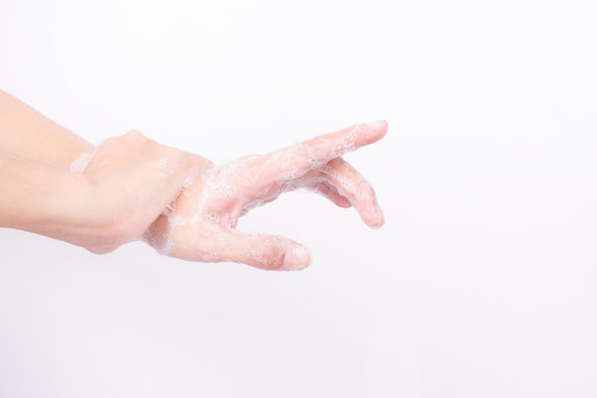 Asian girl hands are washing with soap bubbles on white background
