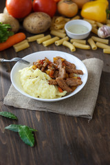 Soy meat with potato puree over kitchen table.